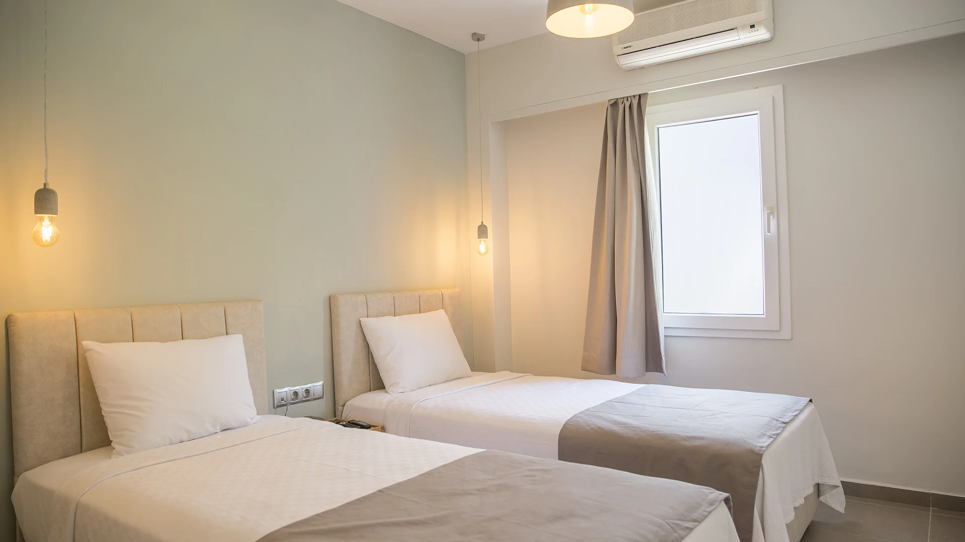 SM Hotels: ti meriti il mare tutto l’anno Camera con due letti singoli, luci sospese e aria condizionata sopra la finestra