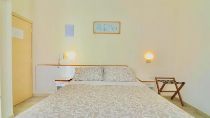 SM Hotels: ti meriti il mare tutto l’anno Letto matrimoniale con copriletto beige in stanza con pareti chiare