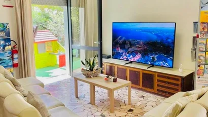 SM Hotels: ti meriti il mare tutto l’anno Soggiorno con divani beige, tavolino, TV e porta finestra aperta
