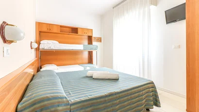 SM Hotels: ti meriti il mare tutto l’anno Camera con letti a castello pieghevoli e letto matrimoniale con copriletto a righe