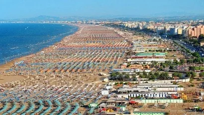 SM Hotels: ti meriti il mare tutto l’anno Vista aerea di una lunga spiaggia affollata con ombrelloni colorati e ville vicino al mare