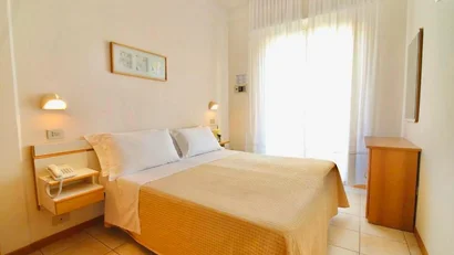 SM Hotels: ti meriti il mare tutto l’anno Camera d'albergo luminosa con letto matrimoniale e mobili in legno chiaro