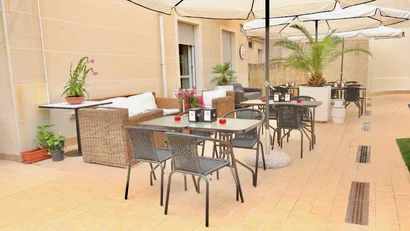 SM Hotels: ti meriti il mare tutto l’anno Tavoli e sedie all'aperto con ombrelloni e piante in un patio soleggiato