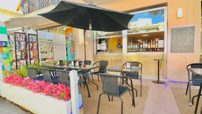SM Hotels: ti meriti il mare tutto l’anno Bar con tavoli all'aperto, ombrellone nero e fiori rosa