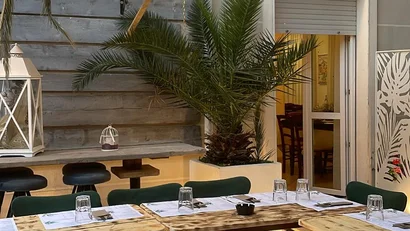 SM Hotels: ti meriti il mare tutto l’anno Tavoli di legno allestiti con menu e bicchieri in un dehor elegante
